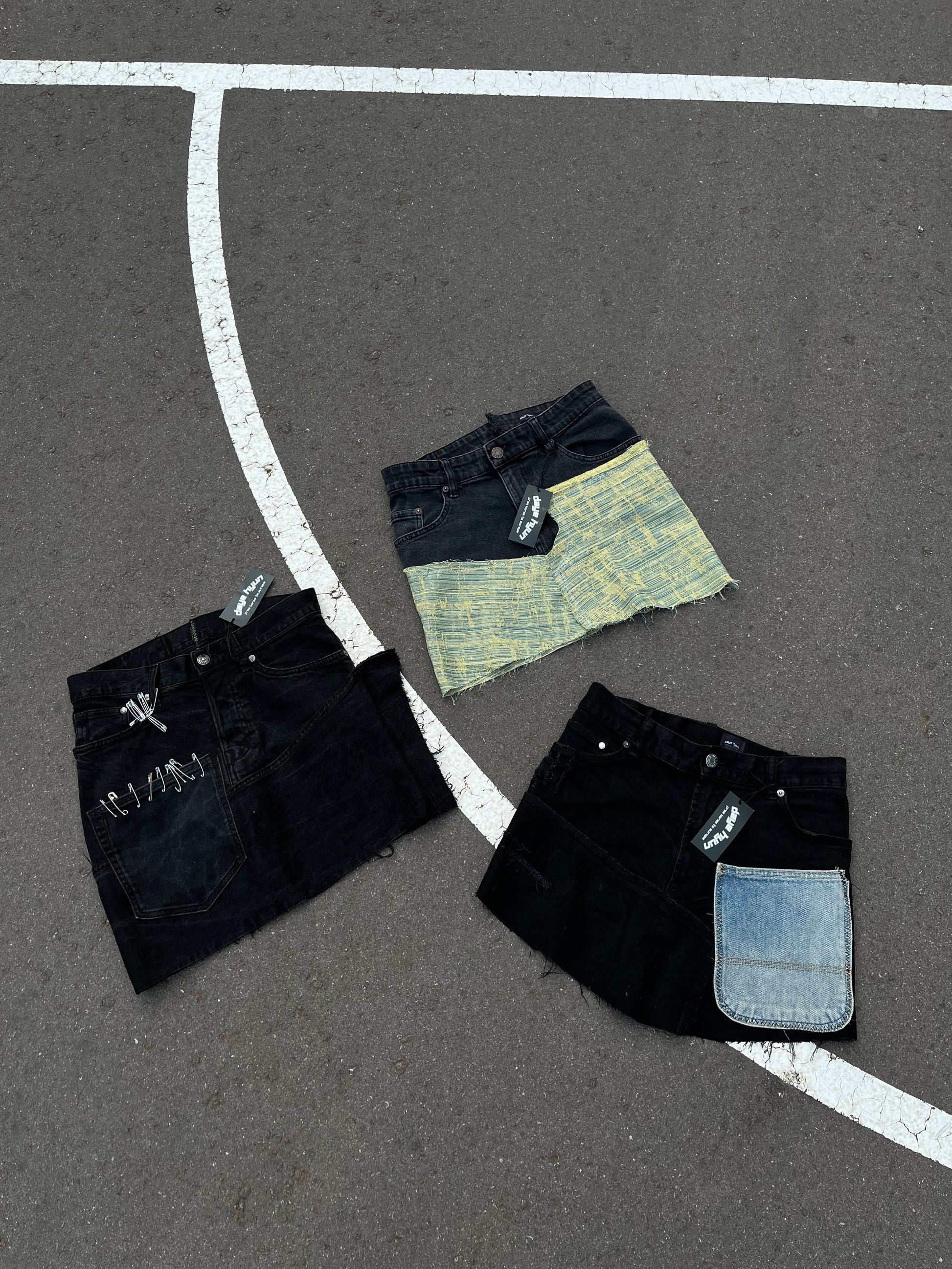 RECONSTRUCTED BLACK DENIM SKIRT W/ BLUE FRONT POCKET.